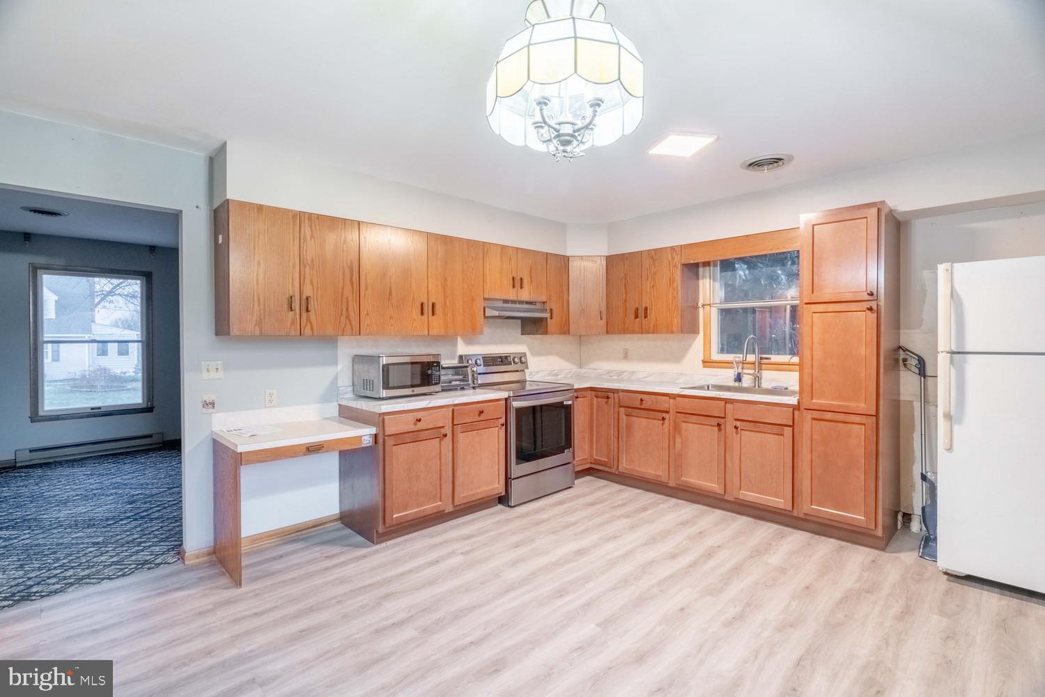 17511 Gay Street Hagerstown, MD 21740 - Photo 7 of 30 a large kitchen with a refrigerator a stove top oven a sink dishwasher and white cabinets with wooden floor