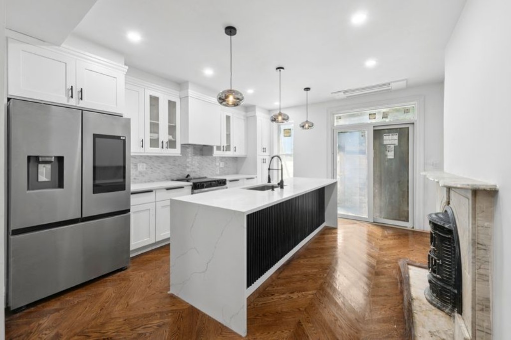 105 St Felix Street, Unit 1 Brooklyn, NY 11217 - Photo 3 of 11 a kitchen with stainless steel appliances granite countertop a refrigerator a sink dishwasher a stove and white cabinets with wooden floor