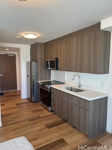 a kitchen with a sink refrigerator and cabinets