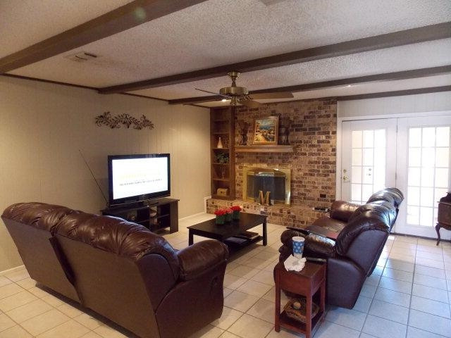 3409 84th Street Lubbock, TX 79423 - Photo 3 of 10 a living room with furniture a fireplace and a flat screen tv
