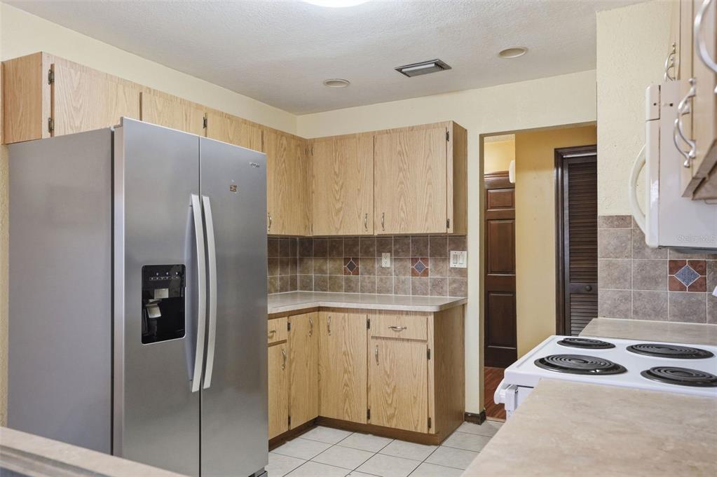 11286 Roland Street Spring Hill, FL 34609 - Photo 11 of 54 a kitchen with stainless steel appliances granite countertop a refrigerator and a stove