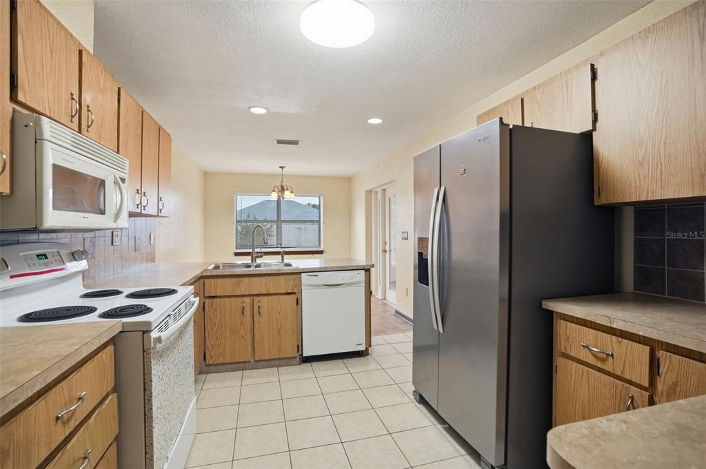 11286 Roland Street Spring Hill, FL 34609 - Photo 12 of 54 a kitchen with a sink stove and refrigerator