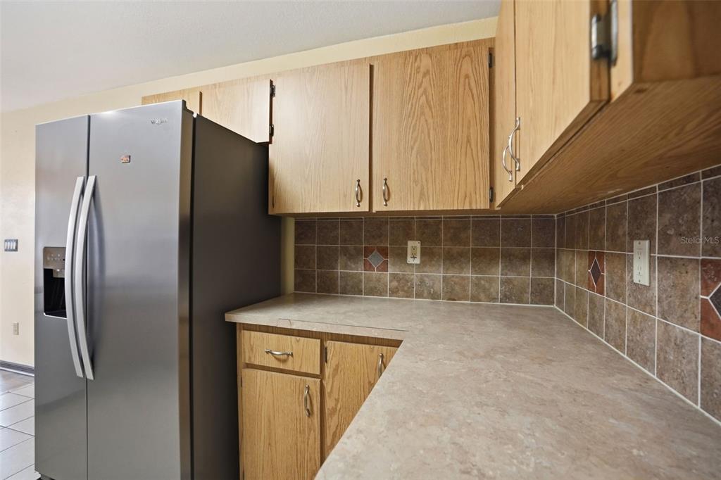 11286 Roland Street Spring Hill, FL 34609 - Photo 15 of 54 a view of a refrigerator in kitchen and an empty room