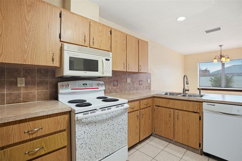 11286 Roland Street Spring Hill, FL 34609 - Photo 16 of 54 a kitchen with cabinets appliances a sink and a counter top space