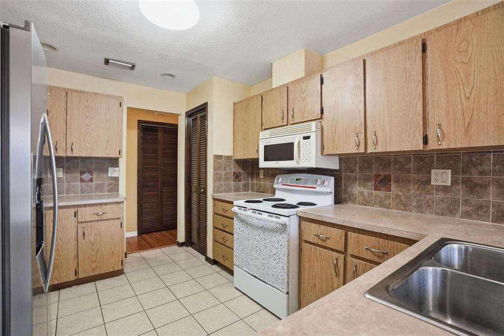 11286 Roland Street Spring Hill, FL 34609 - Photo 17 of 54 a kitchen with a sink stove and refrigerator
