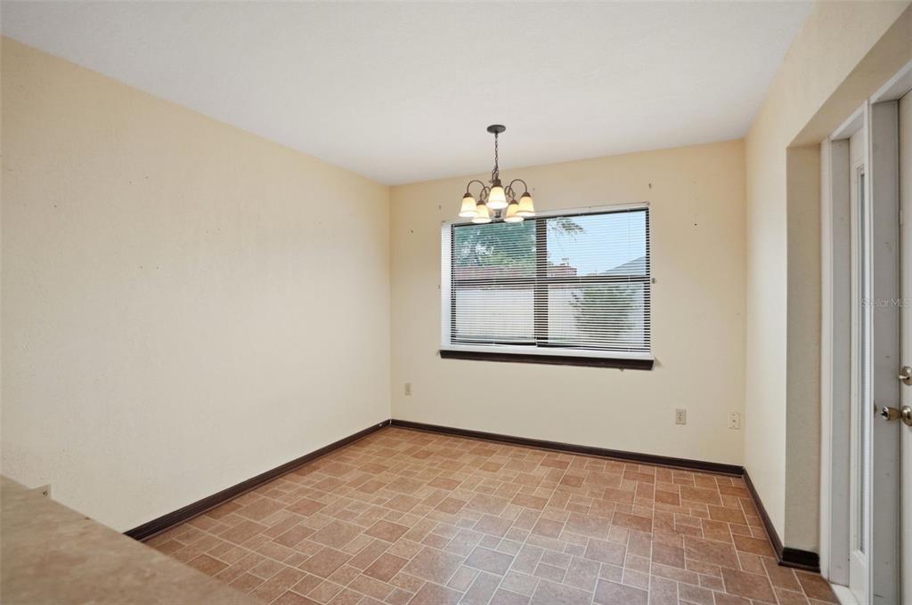11286 Roland Street Spring Hill, FL 34609 - Photo 19 of 54 a view of an empty room with chandelier and window