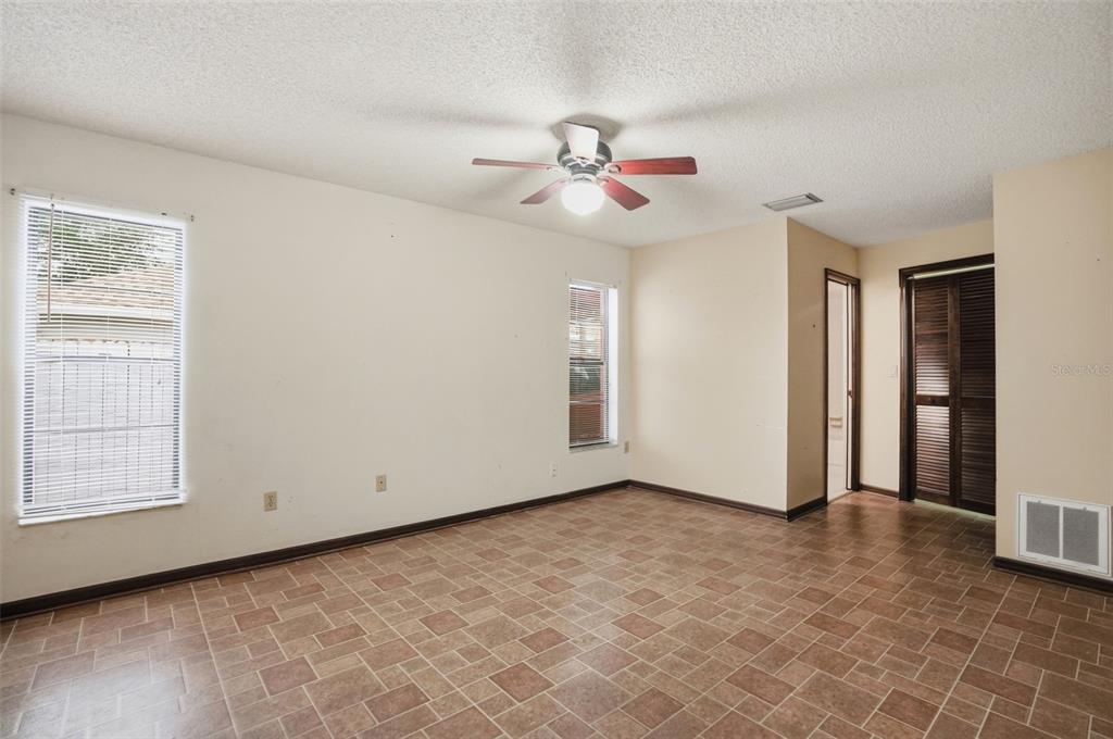 11286 Roland Street Spring Hill, FL 34609 - Photo 22 of 54 an empty room with windows and fan