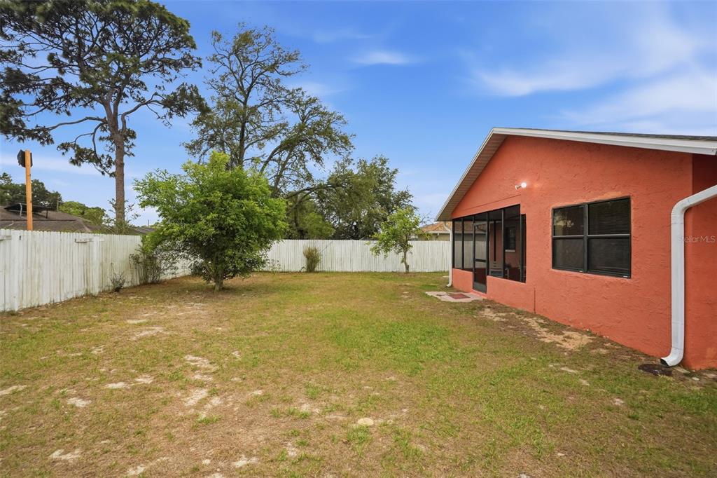 11286 Roland Street Spring Hill, FL 34609 - Photo 38 of 54 a backyard of a house with table and chairs