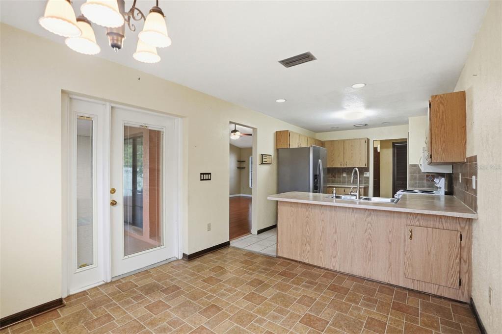 11286 Roland Street Spring Hill, FL 34609 - Photo 10 of 54 a kitchen with stainless steel appliances granite countertop a refrigerator a sink dishwasher a stove and white cabinets