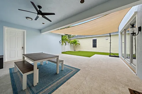 a living room with a patio furniture and a ceiling fan