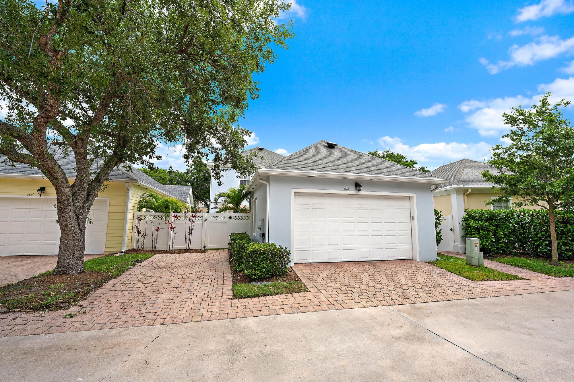 166 Honeysuckle Drive Jupiter, FL 33458 - Photo 22 of 26 a front view of a house with a yard and a garage