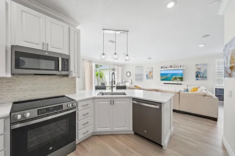 a kitchen with granite countertop a sink cabinets stainless steel appliances and a counter space