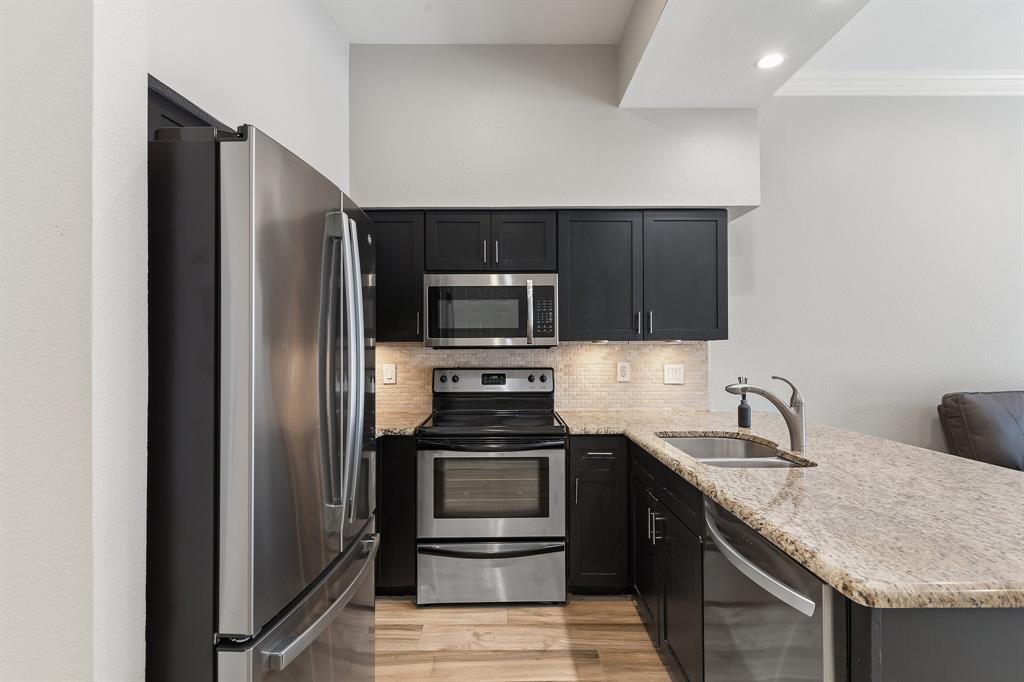 3102 Kings Road, Unit 1106 Dallas, TX 75219 - Photo 5 of 20 a kitchen with granite countertop a refrigerator and a sink
