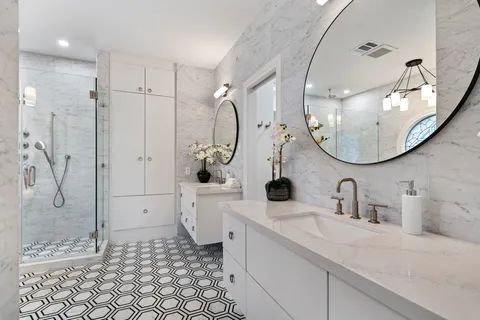 a bathroom with a double vanity sink mirror and shower