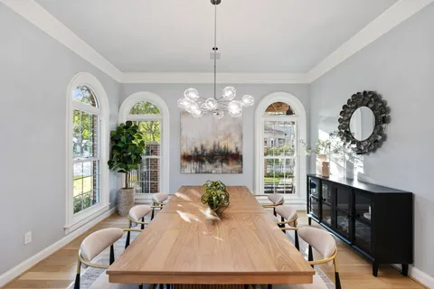 a view of a dining room with furniture a chandelier and window