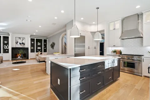 a kitchen with a stove and a wooden floor