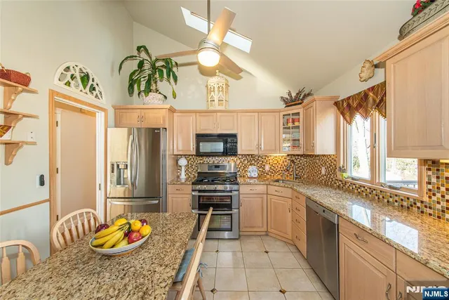 a kitchen with stainless steel appliances kitchen island granite countertop a sink and cabinets