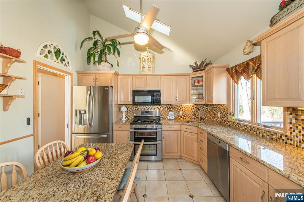 3 Springdale Road West Caldwell, NJ 07006 - Photo 15 of 38 a kitchen with stainless steel appliances kitchen island granite countertop a sink and cabinets