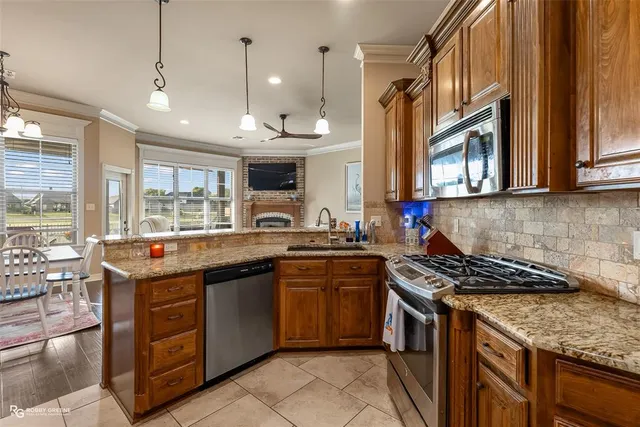 a kitchen with kitchen island granite countertop a sink stove and cabinets
