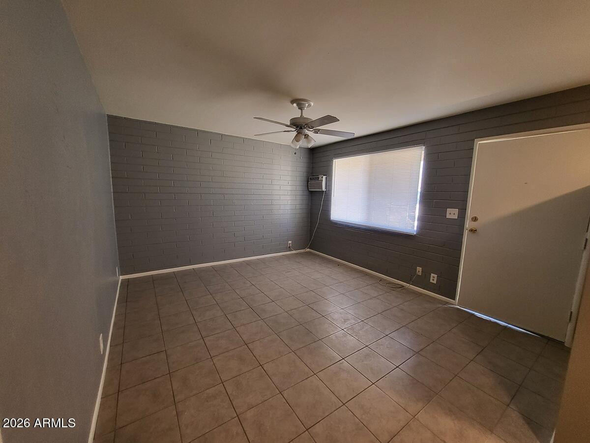 1445 South Kenneth Place, Unit H Tempe, AZ 85281 - Photo 6 of 7 an empty room with windows and fan