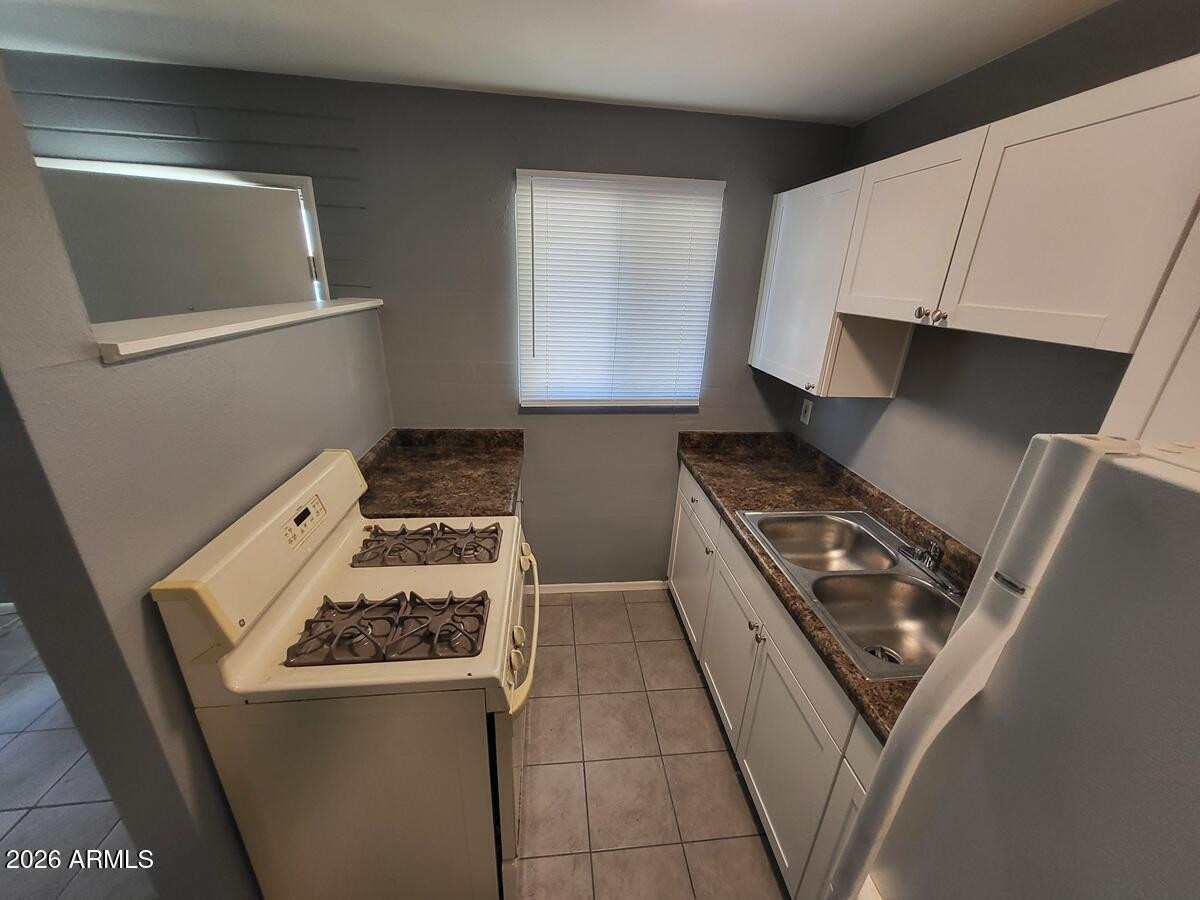 1445 South Kenneth Place, Unit H Tempe, AZ 85281 - Photo 7 of 7 a kitchen with a stove and a microwave