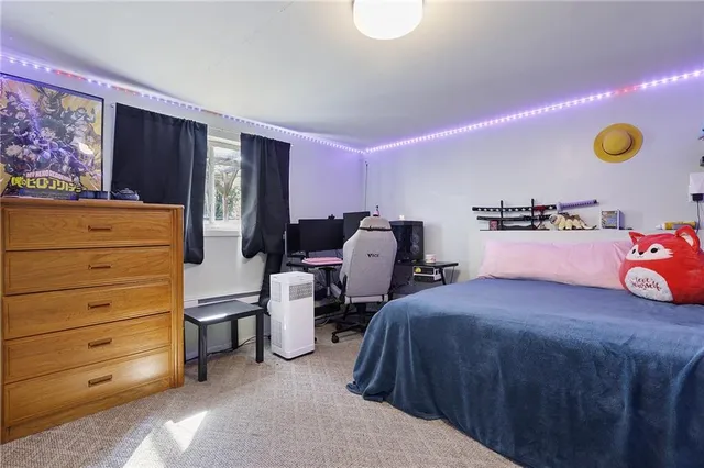 a bedroom with a bed and a lamp on dresser
