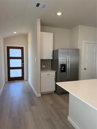 a kitchen with a sink a wooden floor and view living room