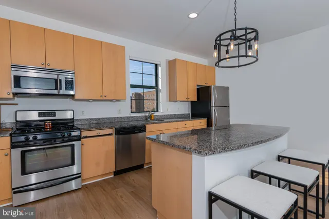 a kitchen with stainless steel appliances granite countertop a stove microwave and sink