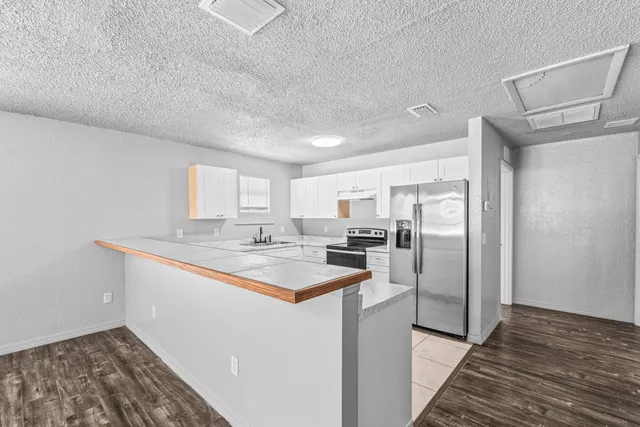 a kitchen with stainless steel appliances a sink and a refrigerator