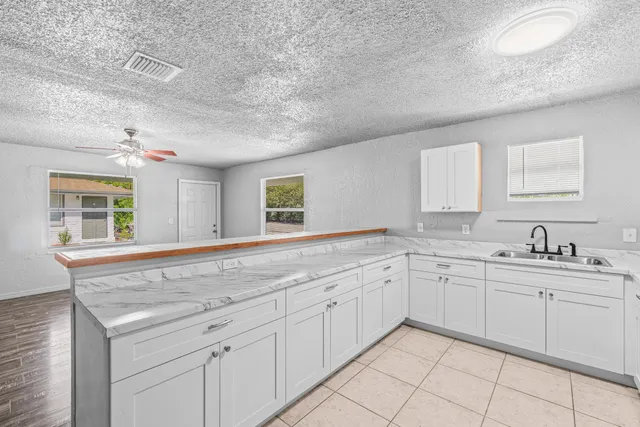 a spacious bathroom with a granite countertop sink mirror and cabinets