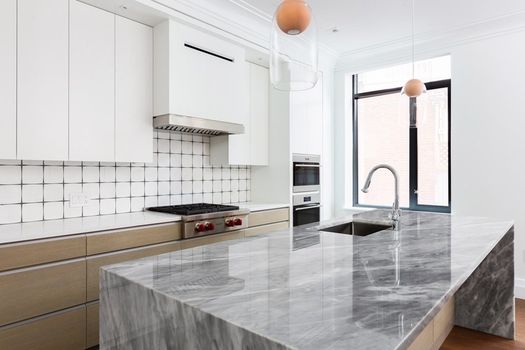 45 Temple Street, Unit 102 Boston, MA 02114 - Photo 4 of 15 a kitchen with granite countertop a sink and a stove
