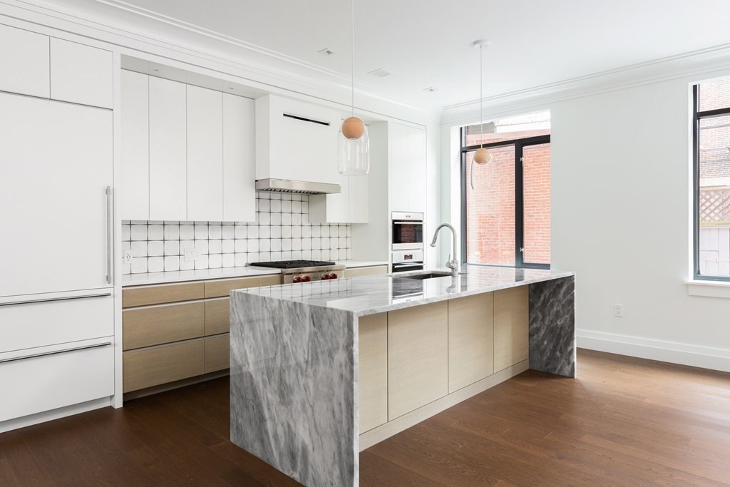 45 Temple Street, Unit 102 Boston, MA 02114 - Photo 5 of 15 a kitchen with cabinets appliances a sink and a window