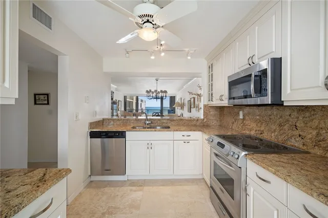 a kitchen with stainless steel appliances granite countertop a sink and stove top oven
