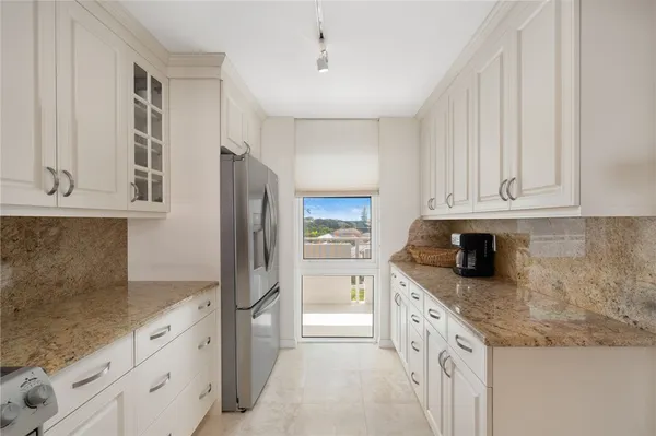 a kitchen with granite countertop white cabinets and stainless steel appliances