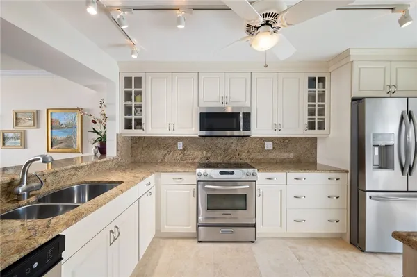 a kitchen with white cabinets and stainless steel appliances