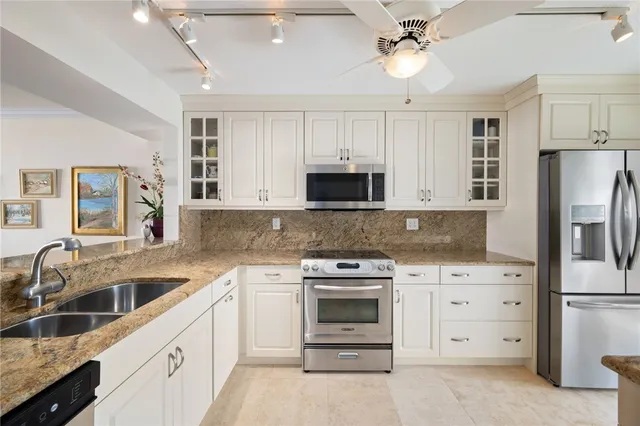 a kitchen with white cabinets and stainless steel appliances