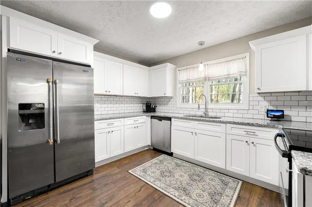 a kitchen with a refrigerator sink and cabinets