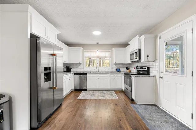 a kitchen with stainless steel appliances granite countertop a refrigerator and a stove top oven