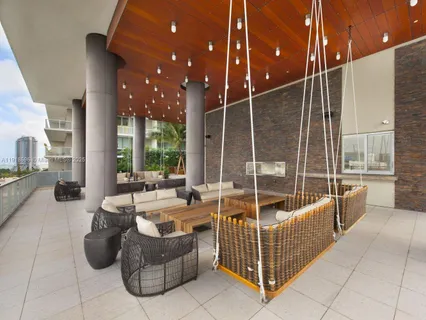 a living room with patio furniture and a floor to ceiling window