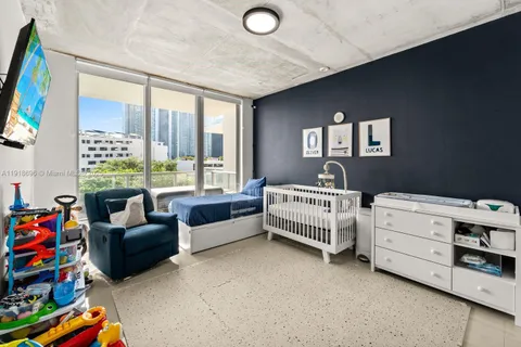 a bedroom with furniture and a large window