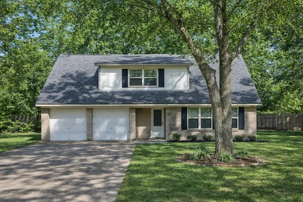 a front view of house with a garden