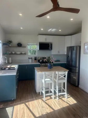 a kitchen with stainless steel appliances granite countertop a refrigerator a sink a stove a microwave and wooden cabinets