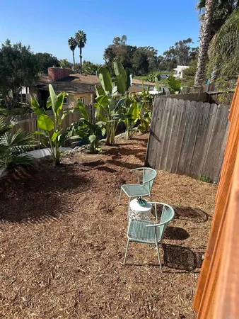 a view of a chairs and table in the backyard