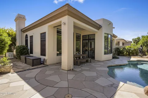 a swimming pool with outdoor seating and yard in the back