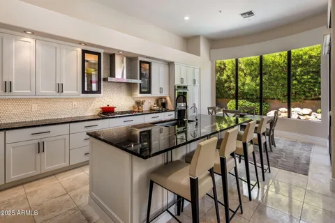 a kitchen with a stove a sink and white cabinets