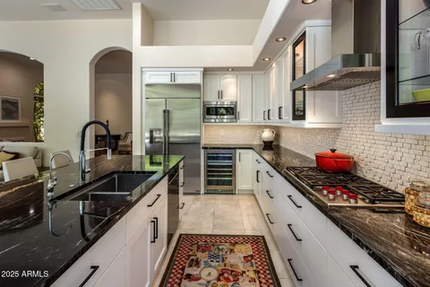 a kitchen with stainless steel appliances granite countertop a sink stove and cabinets
