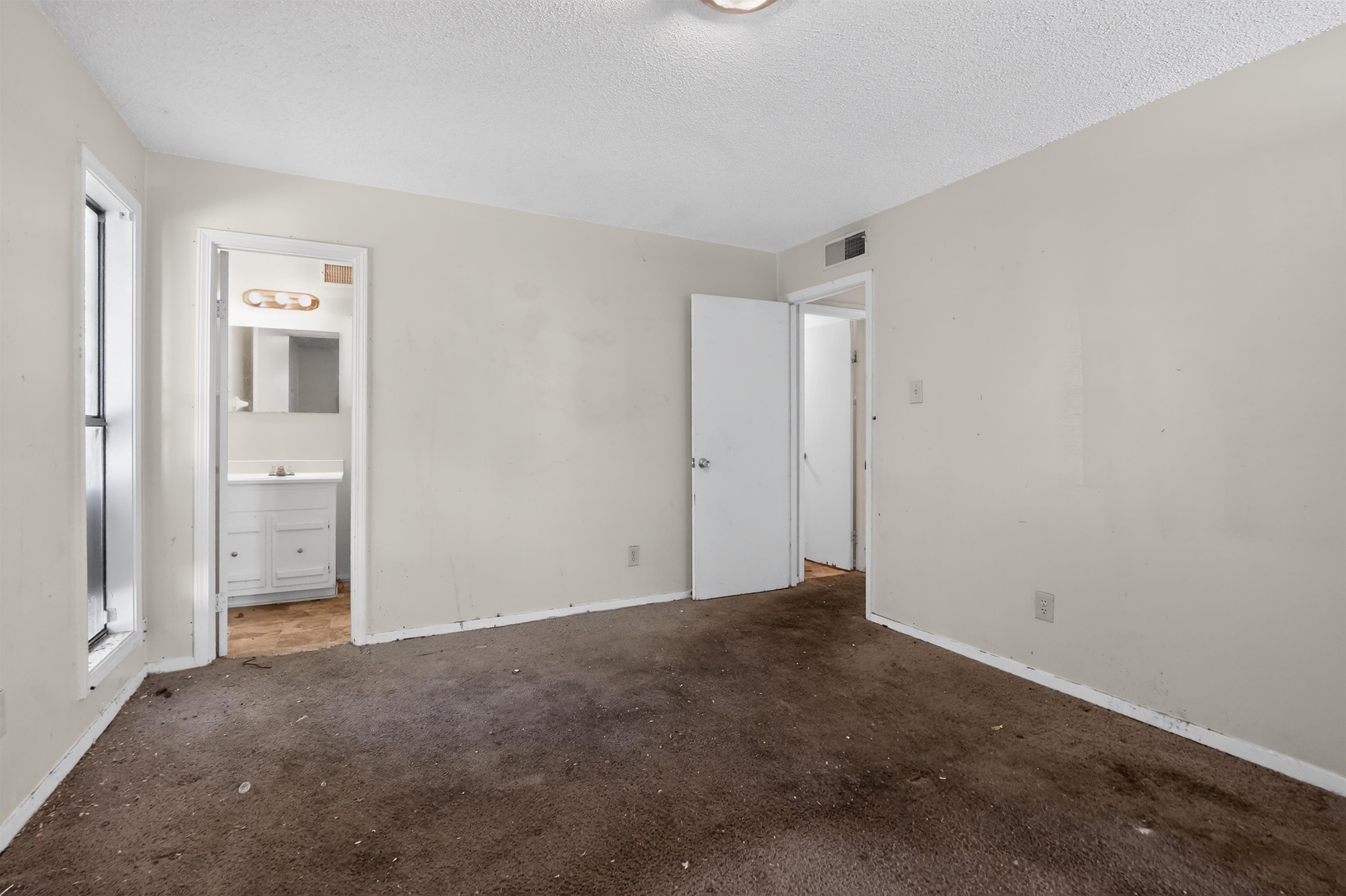 3372 Spring Shadow Drive Memphis, TN 38118 - Photo 26 of 35 Spacious room featuring neutral painted walls, a window with white trim, and a ceiling-mounted light fixture