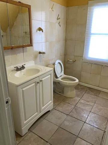 a bathroom with a toilet sink and mirror