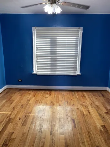 a view of a room with wooden floor and a window