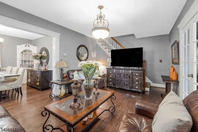 a living room with furniture a flat screen tv and a wall clock